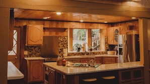 Una cucina accogliente con mobili in legno, un'isola centrale e una finestra che offre luce naturale.