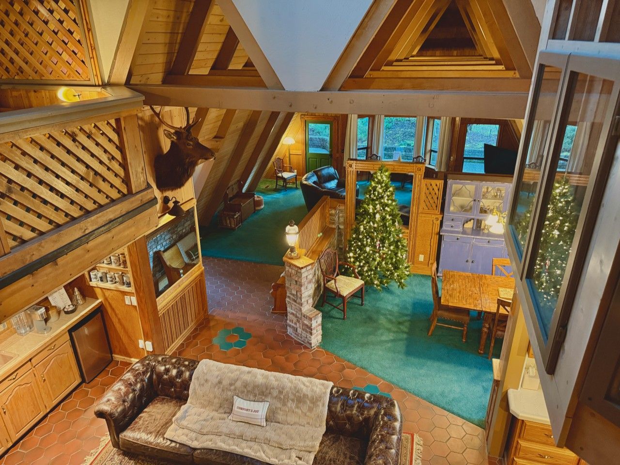 A cozy interior with a fireplace, a Christmas tree, and a dining area.