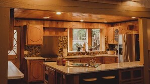 A cozy kitchen with wooden cabinets, a central island, and a window providing natural light.