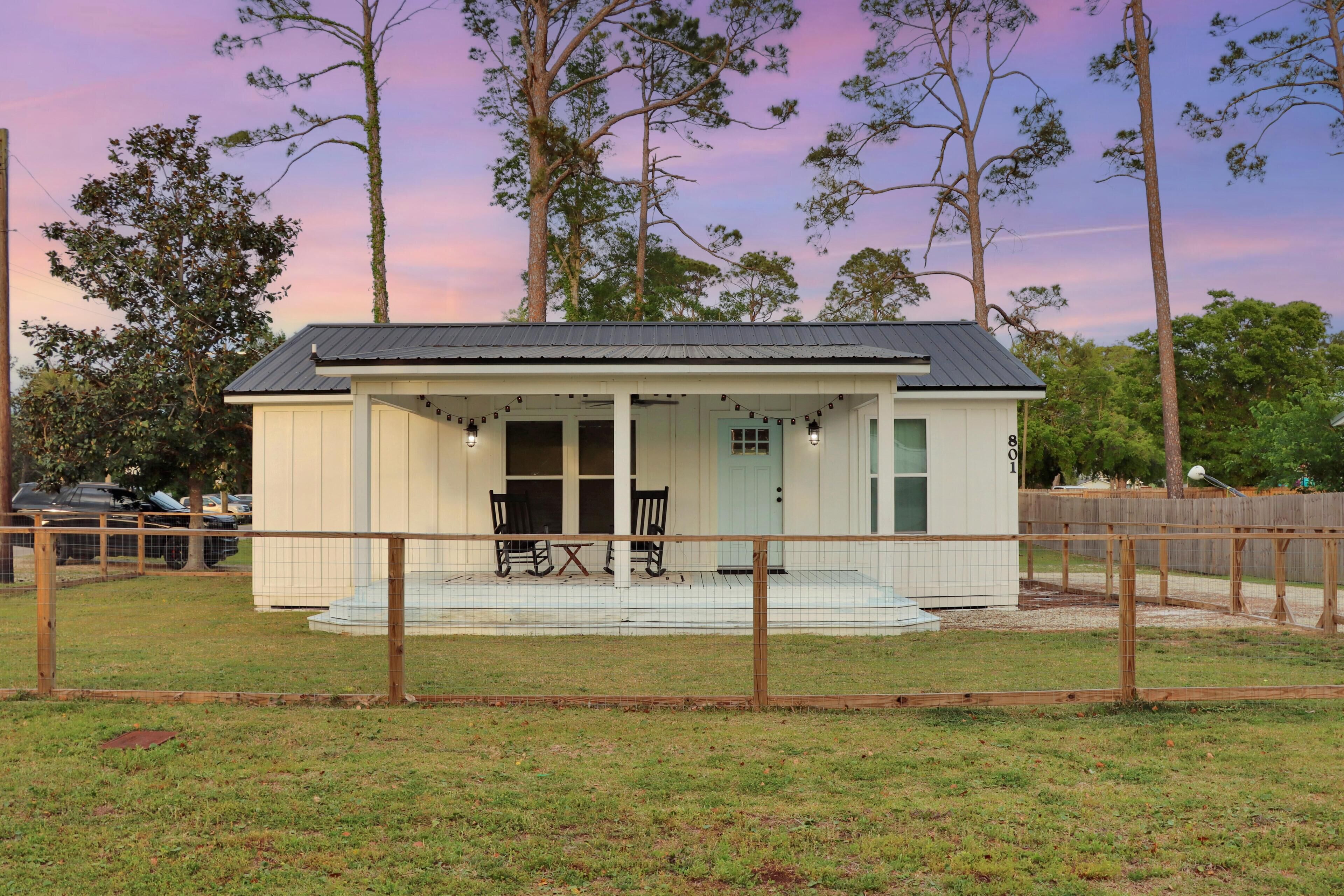 A small, single-story building with a porch and outdoor seating area.