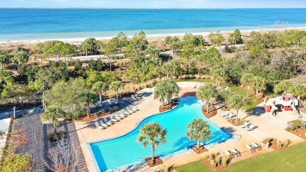 Un complexe hôtelier doté d’une piscine, d’un accès à la plage et de palmiers.