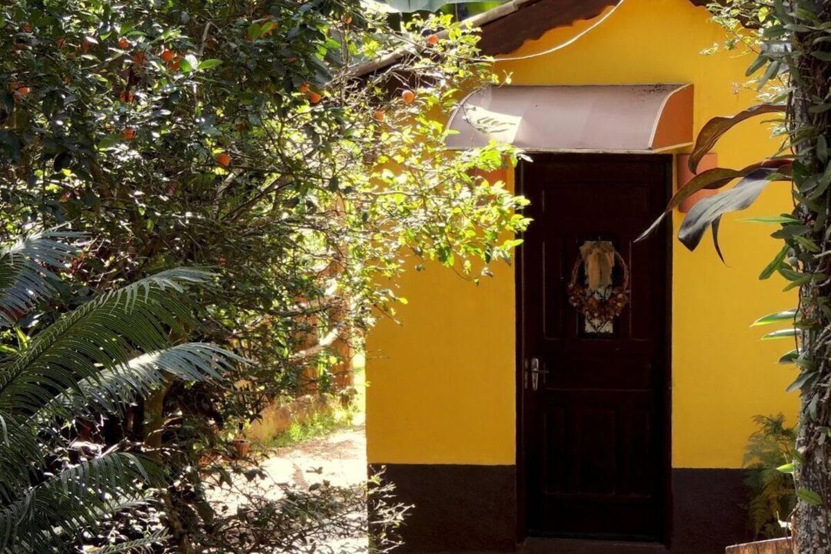 A yellow building with a brown door and a brown awning.