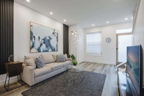 A modern living room with a sofa, coffee table, and artwork on the wall. - Free Parking, Pet Friendly, 3 BDR, Prime Location (Calgary)