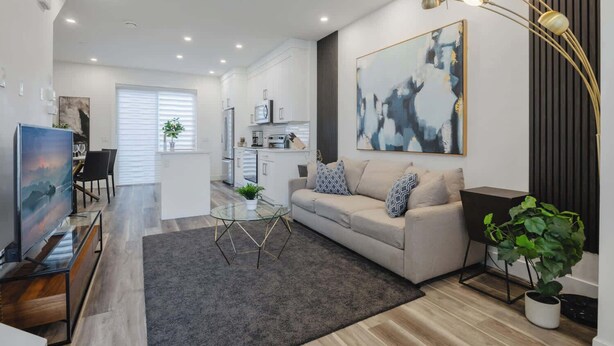 A modern living room with a sofa, coffee table, and artwork.