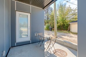 Relax on the covered porch with comfortable seating for four, featuring a convenient entrance to the building.