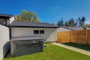 A house with a garage, a wooden fence, and a lawn.