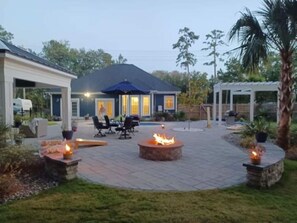 A patio area with a fire pit, outdoor seating, and a covered structure. - Horseshoe Manor (Little River)