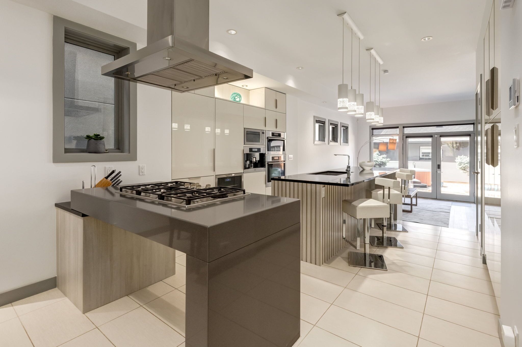 A modern kitchen with a central island, built-in appliances, and a view to the living area.