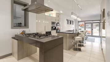 A modern kitchen with a central island, built-in appliances, and a view to the living area.