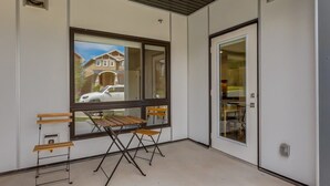Una habitación con un ventanal grande, una mesa de madera y dos sillas.