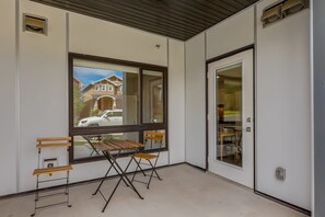 Une pièce avec une grande fenêtre, une table en bois et deux chaises.