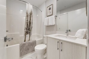Une salle de bain moderne avec une baignoire, des toilettes et un lavabo.