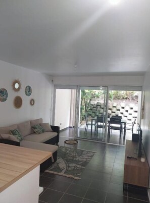 Una sala de estar con sofá, una mesa de centro y un comedor con sillas y una mesa.