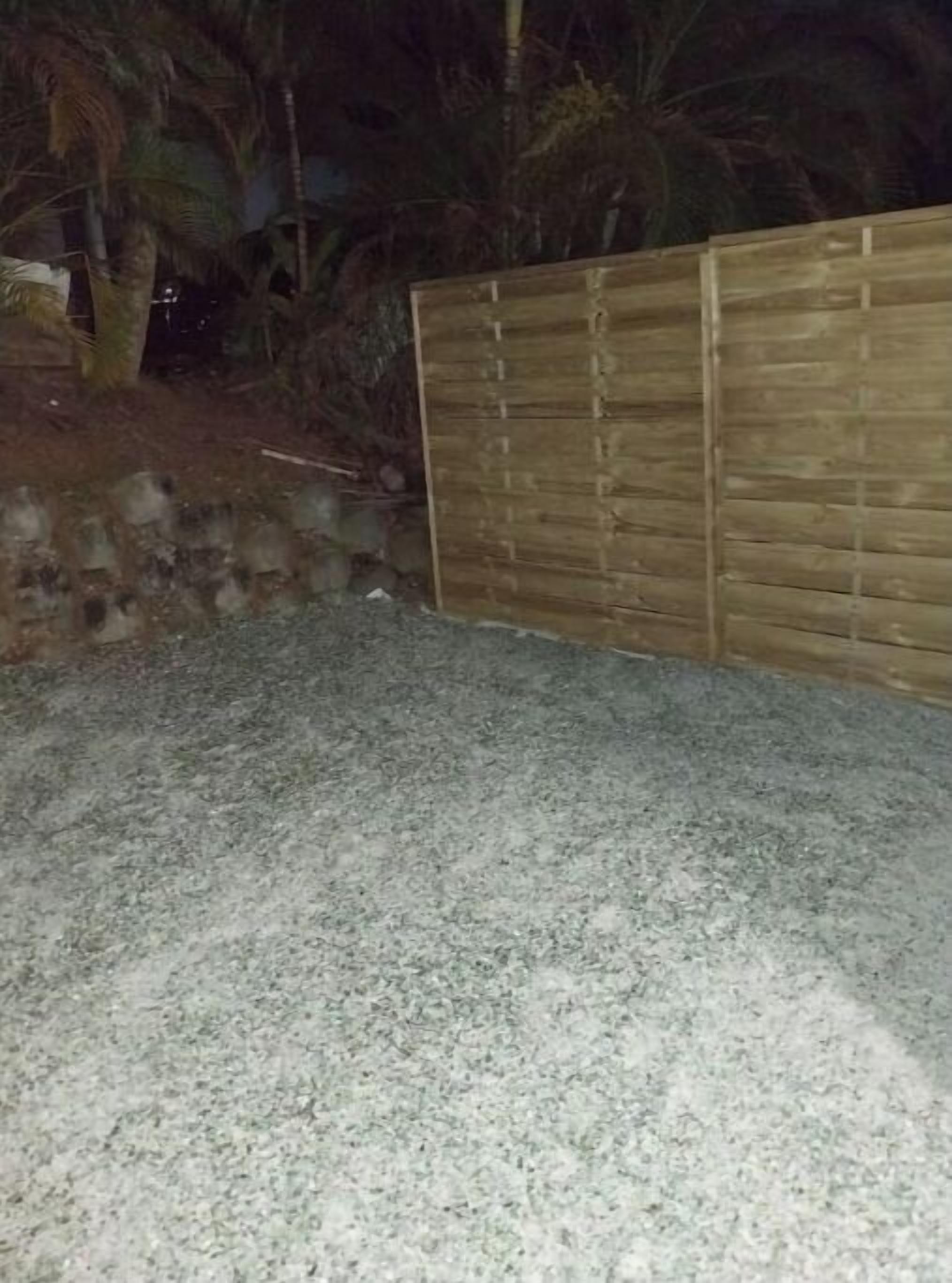 Un espace extérieur aménagé avec une surface pavée et une clôture en bois.