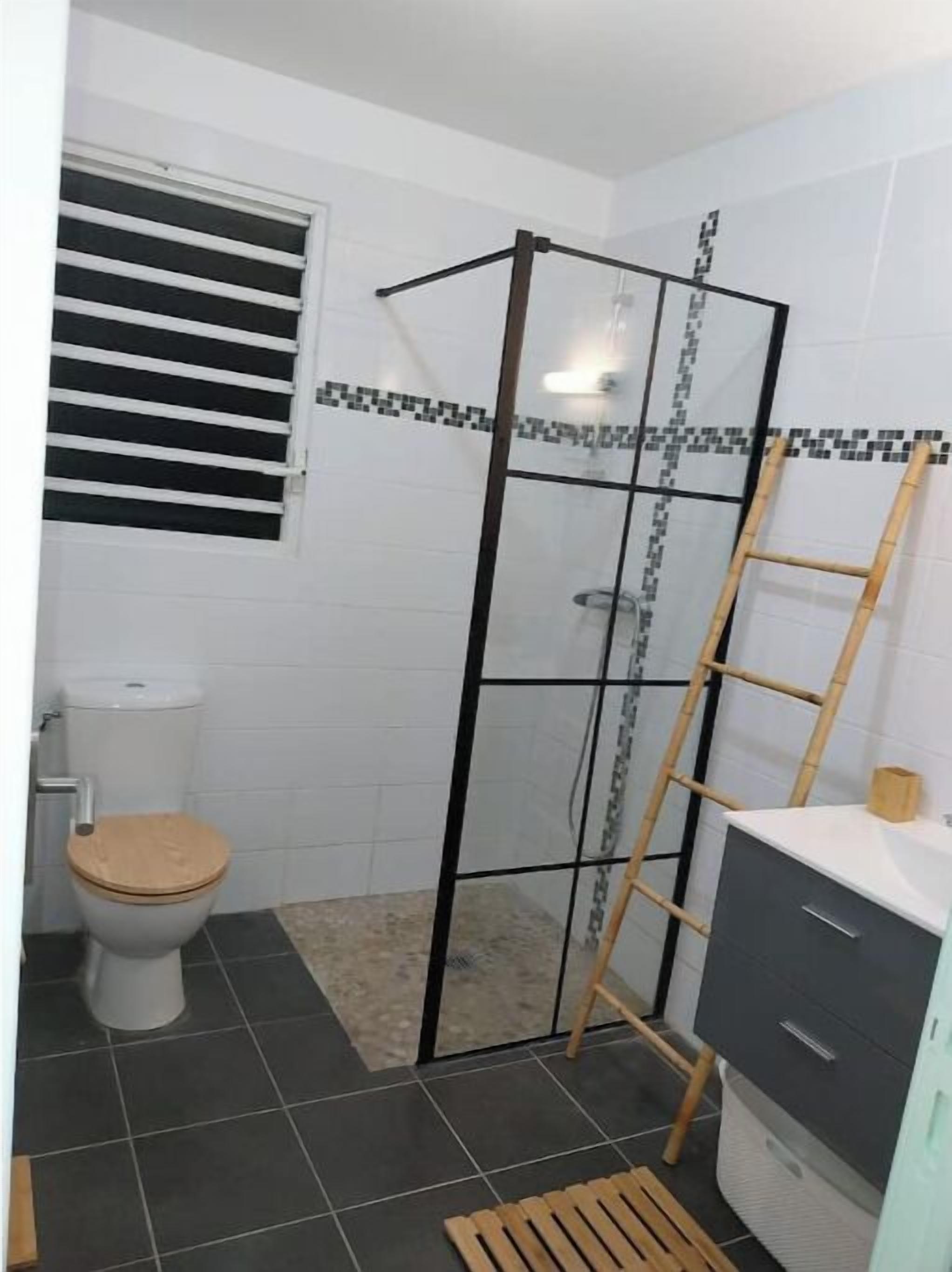 Een badkamer met een douche, toilet en wastafel.