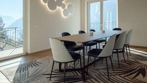 Una sala da pranzo moderna con un tavolo grande, sei sedie e un tappeto decorato.