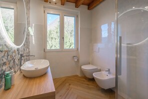 Ein modernes Badezimmer mit zwei Waschbecken, einer Toilette und einer Dusche.