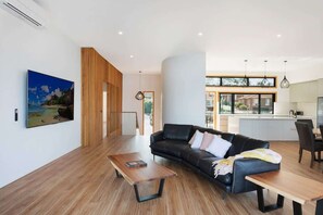 A modern living room with a sofa, coffee table, and artwork on the wall.