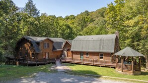A log cabin with a porch and a gazebo, surrounded by a forest. - Family & Dog Friendly Escape w/ 2 Hot Tubs (McHenry)