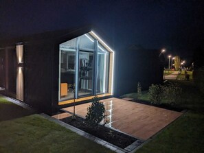 Una casa moderna con ampie vetrate e uno spazio esterno luminoso.