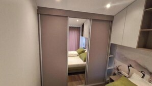 A bedroom with a bed, a mirror, and a wardrobe.