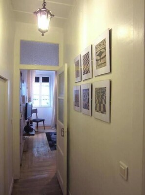 Stylish hallway leads to a room with a window and framed artworks.