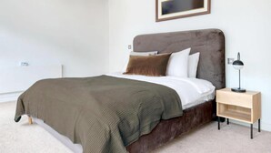 A bedroom with a bed, a bedside table, and a nightstand. - Amazing Place by Liverpool St Station (London)