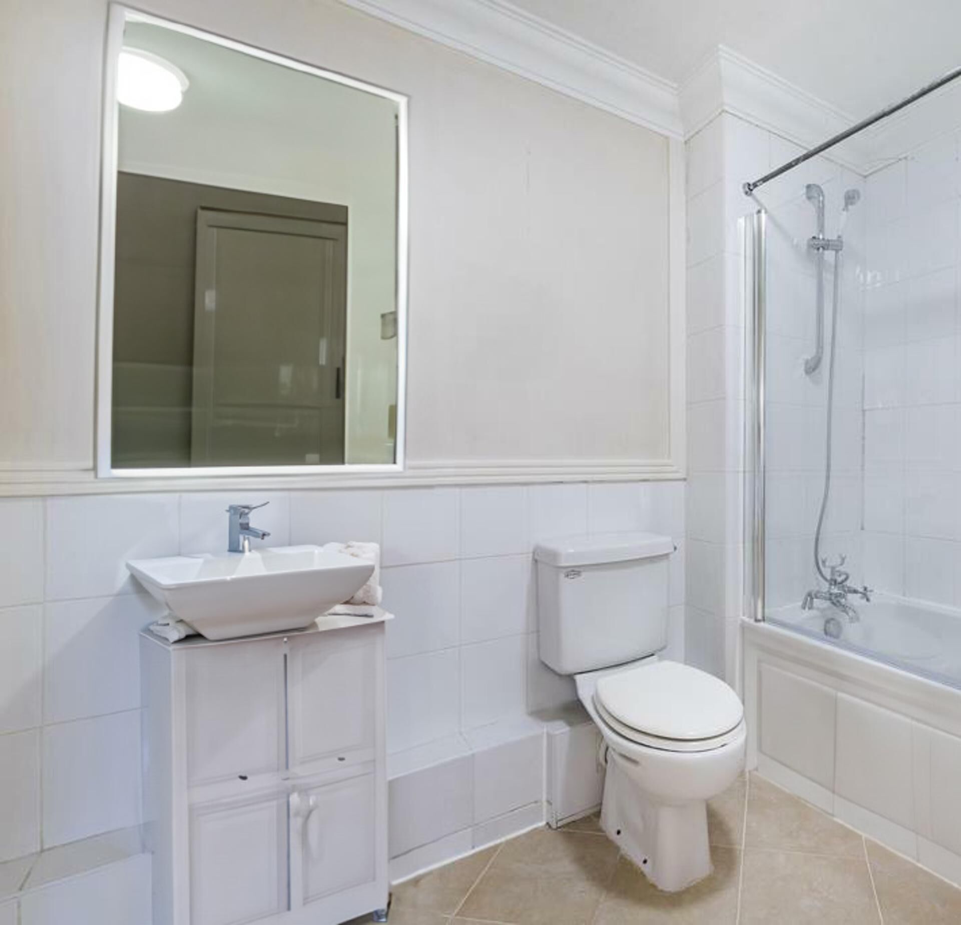 Ein modernes Badezimmer mit Waschbecken, Toilette und Dusche in Weiß.