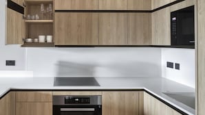 A modern kitchen with wooden cabinets, a stainless steel oven, and a microwave. - Charming 2 Bedrooms Apartment in London (London)