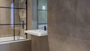 A modern bathroom with a glass-enclosed shower, a freestanding bathtub, and a large mirror. - Charming 2 Bedrooms Apartment in London (London)