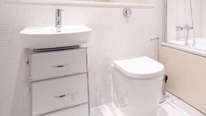 A modern bathroom with a white sink, mirror, and shower. - Cozy 2 Bedrooms by Shoreditch (London)