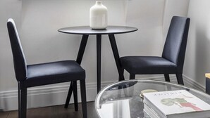 A corner room with a window, two chairs, a small table, and a glass table with a book. - Cozy 2 Bedrooms by Shoreditch (London)