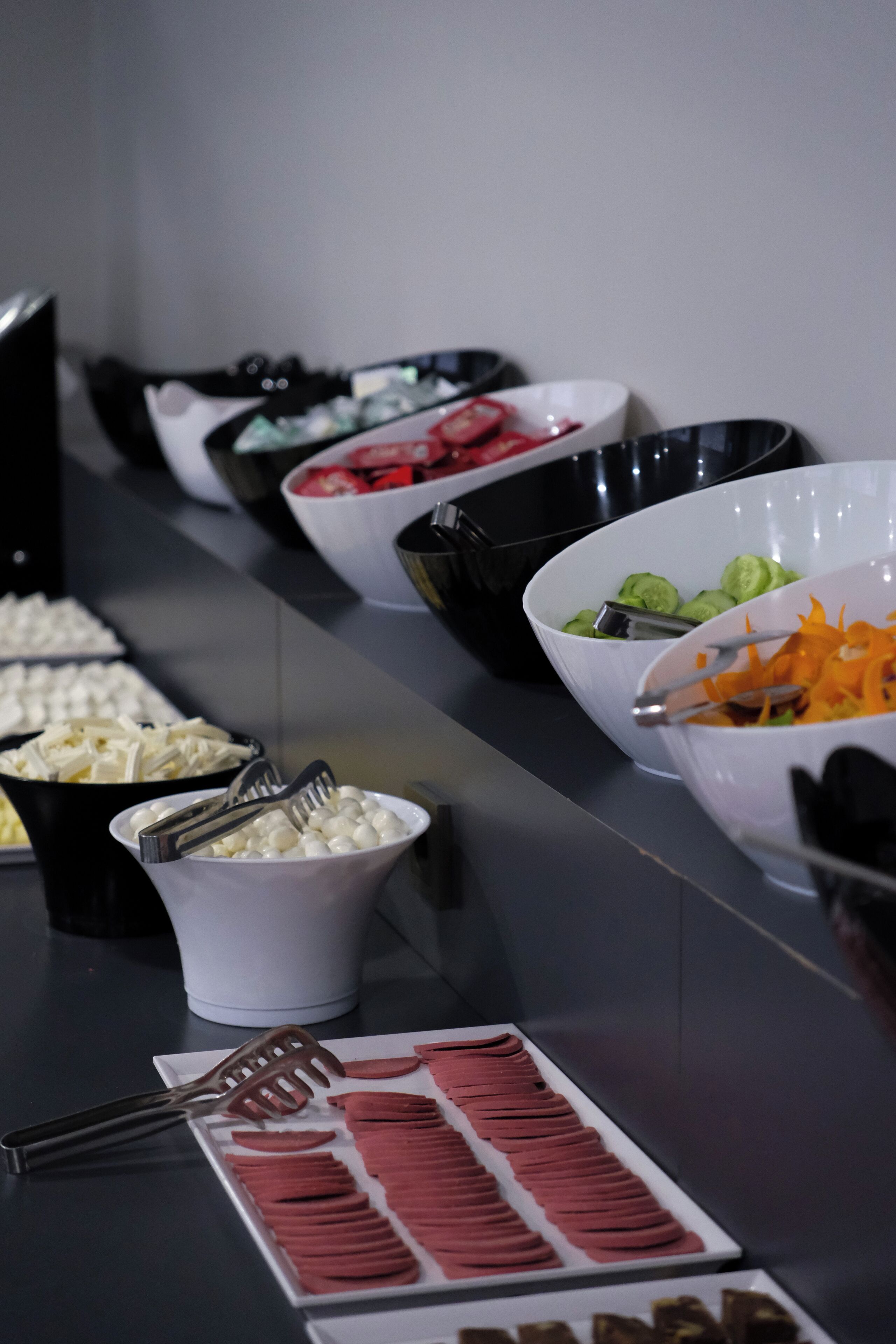 A buffet table with various food items and utensils.