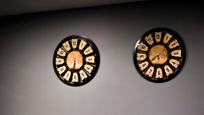 A reception area with two wall clocks and a reception desk.