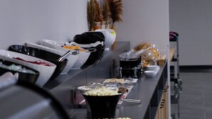 A buffet setup with various food items and utensils.