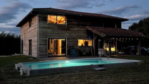 A two-story house with a swimming pool in the front yard.