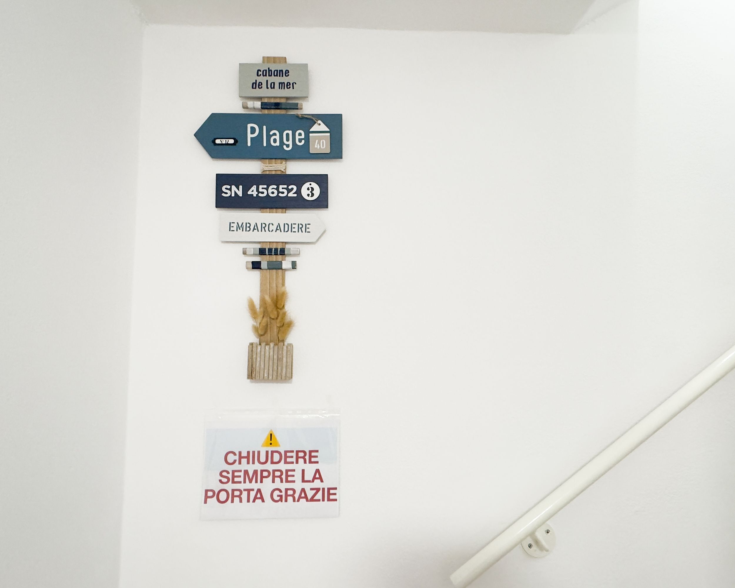 Una pared con señales de orientación y un letrero de precaución.