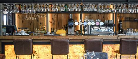 A bar area with a counter, bar stools, and a seating area with tables and chairs.