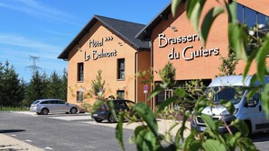 Un edificio con letreros que indican "Hotel Le Belmont" y "Brasserie du Guiers".