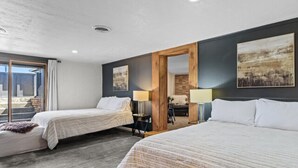 Una habitación de hotel moderna con dos camas, un ventanal grande y vistas al exterior.