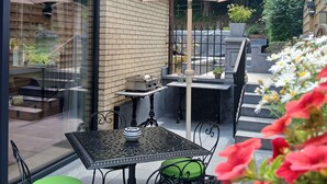 An outdoor patio with a table and chairs, a grill, and a large umbrella. - Évasion nature au Loft du Renard –  Calme et vue boisée près de Namur (Namur)