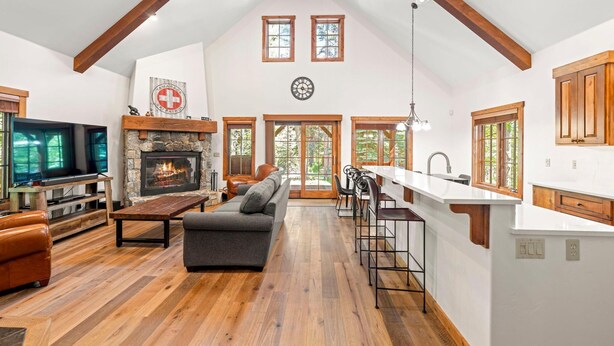 A spacious living area with a stone fireplace, a large sofa, and a television.