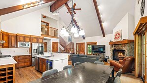 A spacious kitchen with wooden cabinets, a central island, and a dining area with a large table.