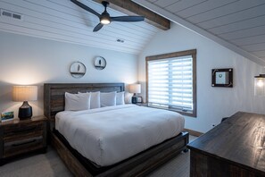 A bedroom with a large bed, wooden headboard, two bedside tables with lamps, a ceiling fan, and a window with blinds. - Comfortable 2 Bedroom Townhome  | Ski in/Ski Out (Tamarack)