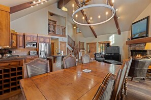 A spacious kitchen with wooden cabinets, a dining area with a large wooden table, and a fireplace.