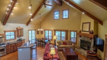A spacious living area with a fireplace, a dining table, and a kitchen with wooden cabinets.