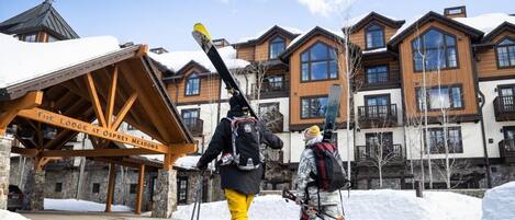 A lodge with a wooden facade, multiple balconies, and a sign reading "The Lodge at Osprey Meadows."