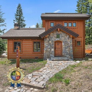 A log cabin with a stone entrance, a number 17 sign, and a TAMARACK ADVANTAGE sign. - Wonderful Cottage |Ski In/Out | Private Hot Tub (Tamarack)
