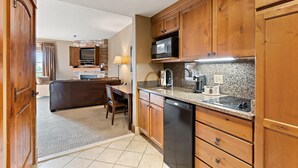 A kitchen with wooden cabinets, a microwave, a dishwasher, and a granite countertop.