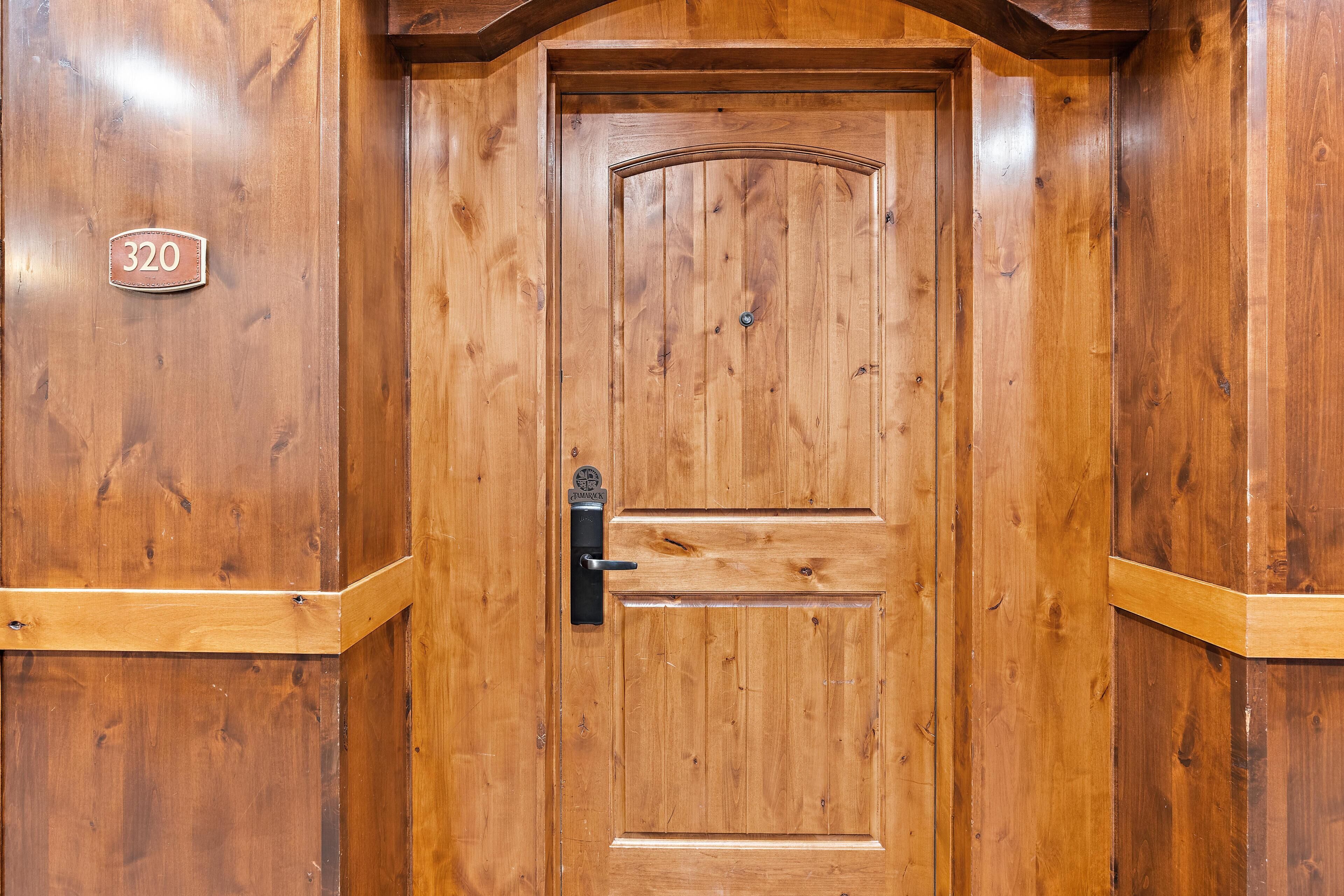 Una porta in legno con una targa, una maniglia e una serratura.